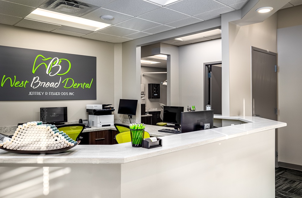 Modern reception counter at West Broad Dental with the practice logo displayed on the back wall.