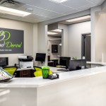 Modern reception counter at West Broad Dental with the practice logo displayed on the back wall.