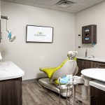 Clean clinical exam room at West Broad Dental with an intraoral X-ray unit and dental care equipment.