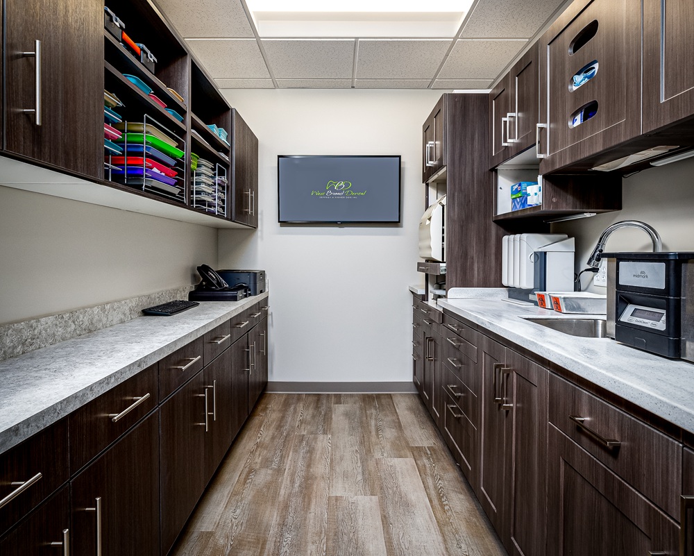 Sterilization and instrument preparation bay at West Broad Dental with custom cabinetry and sanitation equipment.